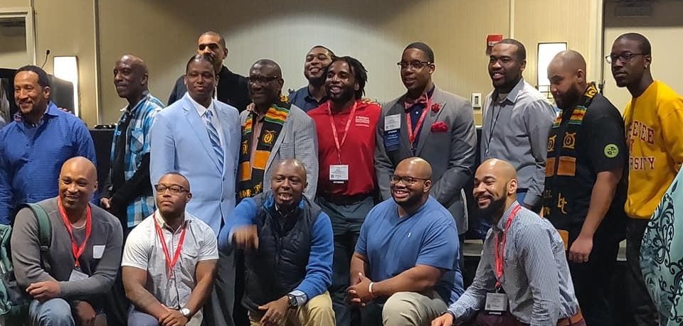 Picture of Dr. Fredrick standing in a group of almost 20 Black male occupational therapists